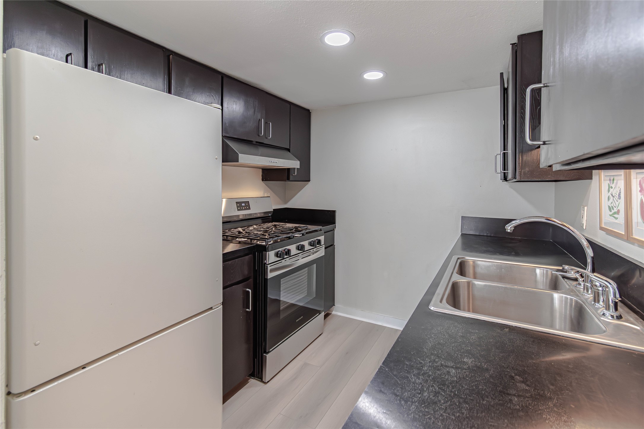 1800 Lavaca Street, Unit A705 Austin, TX 78701 - Photo 7 of 18 a kitchen with granite countertop a sink stainless steel appliances and cabinets
