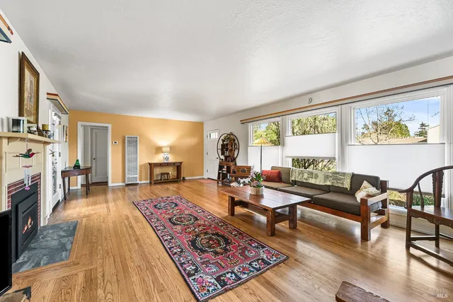 a living room with fireplace furniture and a large window