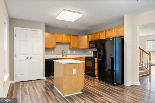 a kitchen with stainless steel appliances granite countertop a refrigerator and a stove top oven