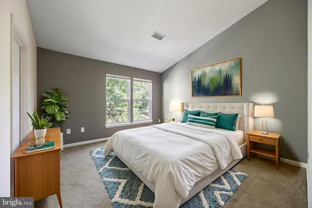 a bedroom with a large bed and a potted plant