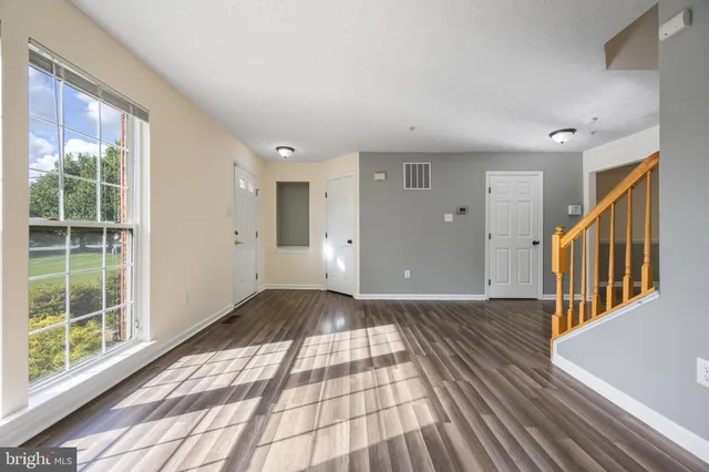 a view of a room with wooden floor and windows