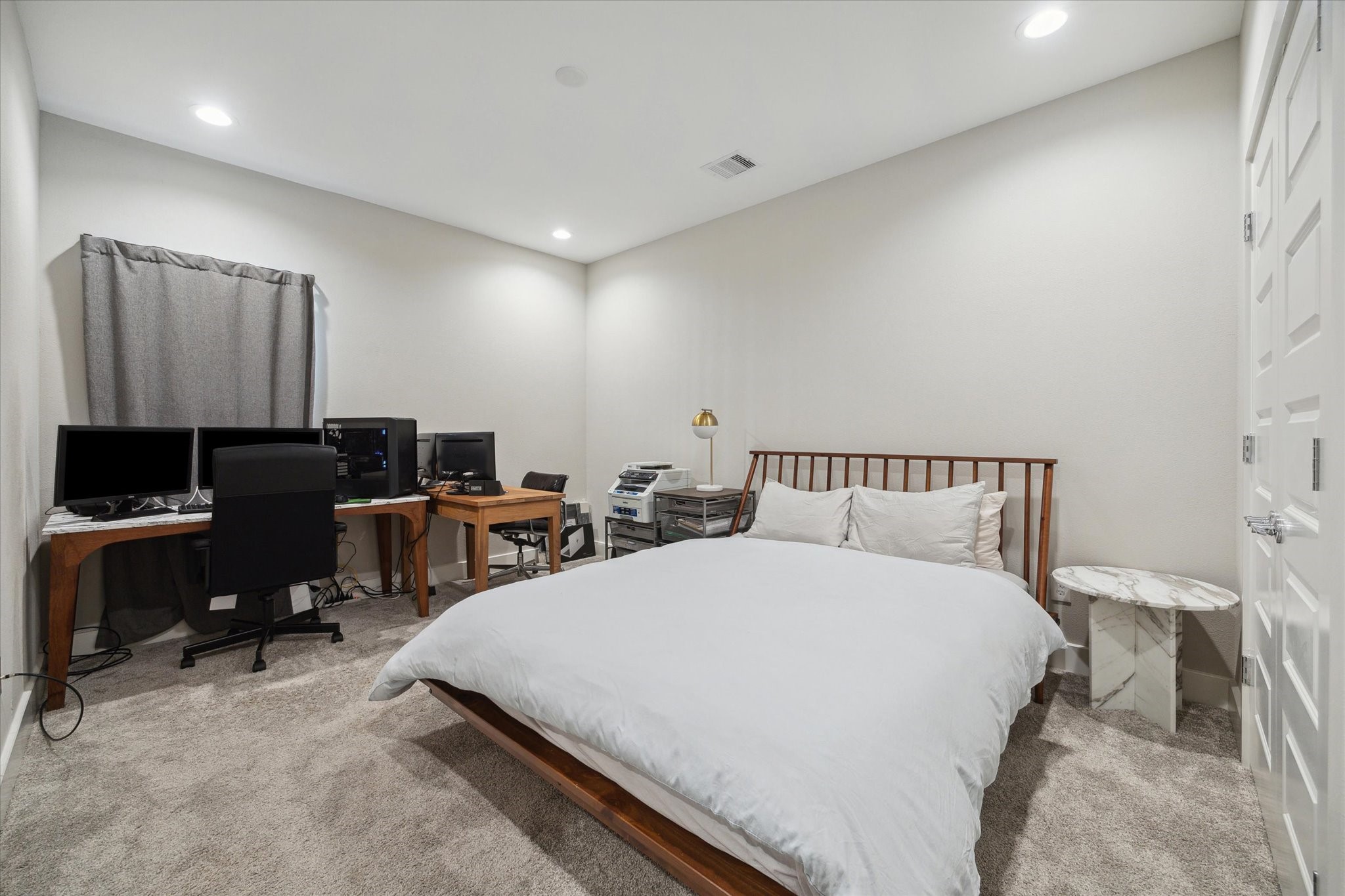 9414 Campbell Road, Unit F Houston, TX 77080 - Photo 20 of 26 a large bedroom with bed tv and a desk