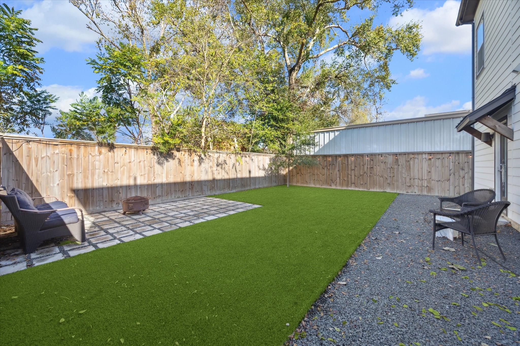 9414 Campbell Road, Unit F Houston, TX 77080 - Photo 22 of 26 a view of a backyard with table and chairs potted plants and a wooden fence