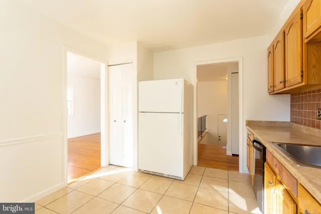 a kitchen with a refrigerator a stove top oven and cabinets