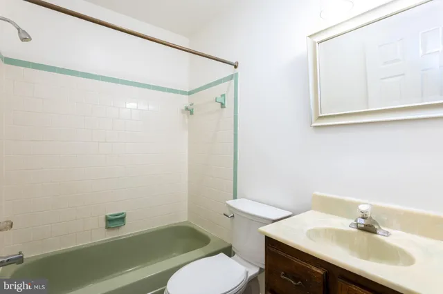 a bathroom with a sink mirror vanity and toilet