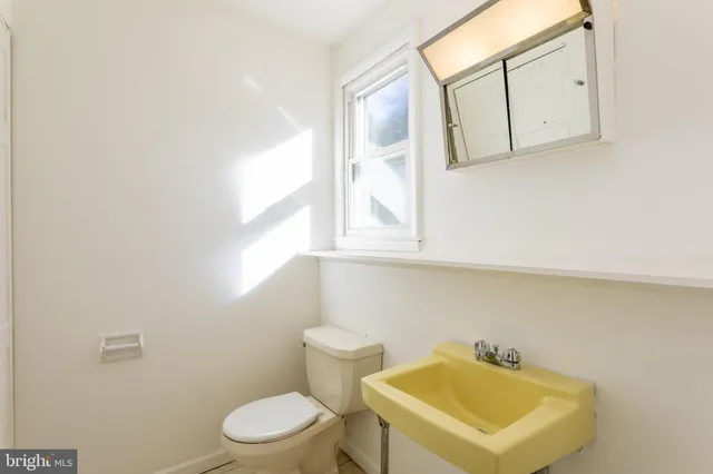 a bathroom with a sink a toilet and mirror