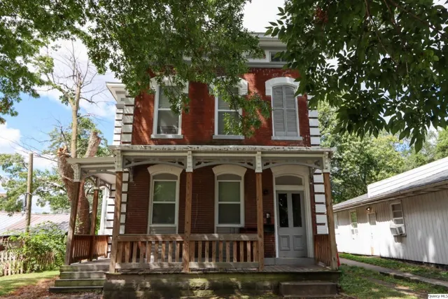 a front view of a house with a garden and plants