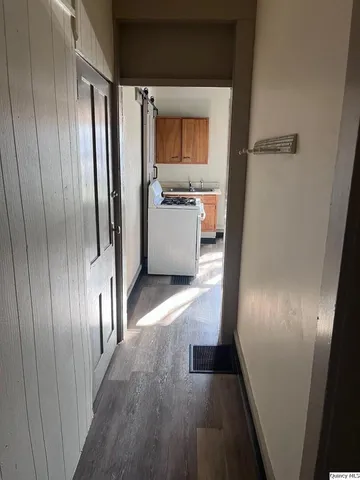 a view of entryway and gallery with wooden floor