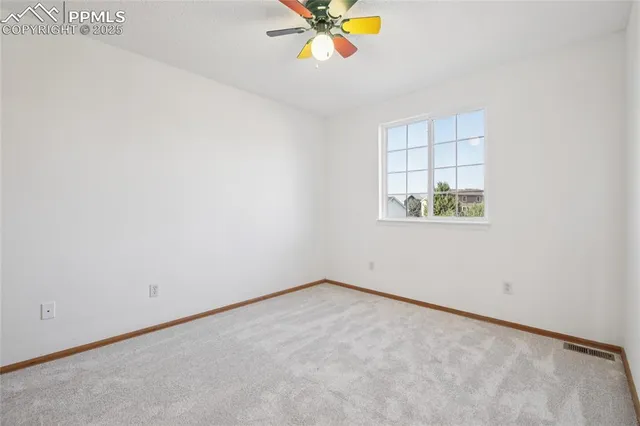 an empty room with a window and a ceiling fan