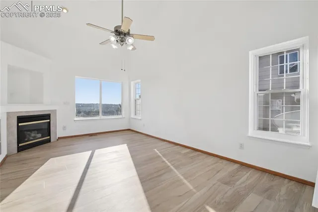 a view of an empty room with a fireplace and a window