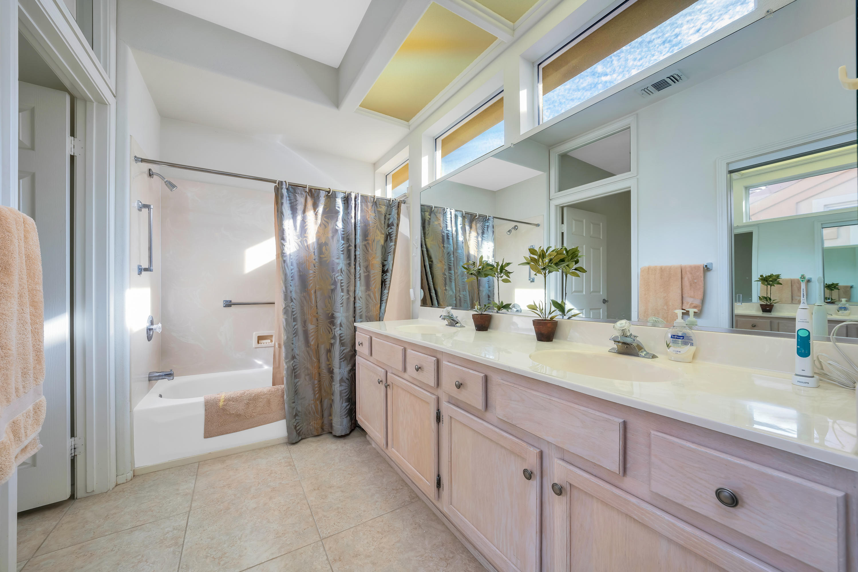 37395 Purple Shadow Road Palm Desert, CA 92211 - Photo 16 of 19 a spacious bathroom with a shower a sink and a large mirror