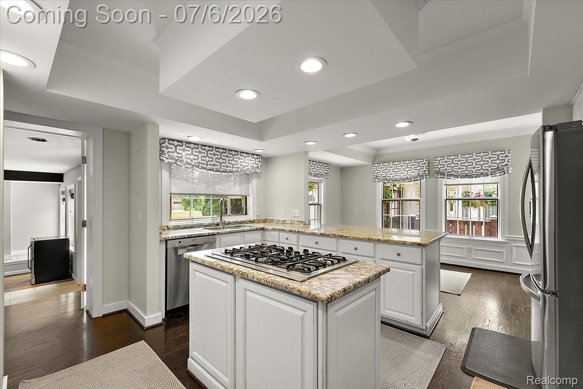 1051 Devonshire Road Grosse Pointe, MI 48230 - Photo 10 of 98 Kitchen featuring a central island with a gas range, perimeter cabinetry with stone countertops, recessed lighting, and hardwood flooring
