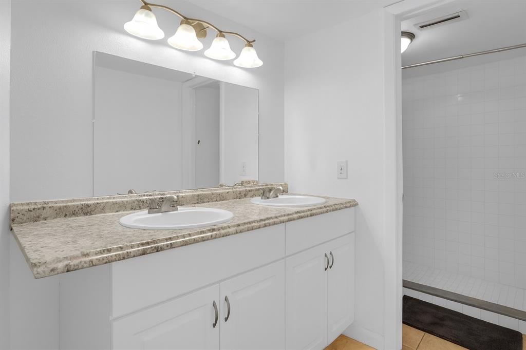 2604 Lemon Tree Lane, Unit C Orlando, FL 32839 - Photo 12 of 24 a bathroom with a granite countertop sink and a mirror