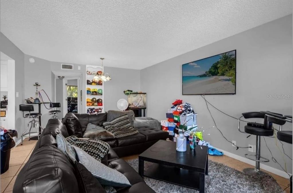 2604 Lemon Tree Lane, Unit C Orlando, FL 32839 - Photo 15 of 24 a living room with furniture and a chandelier