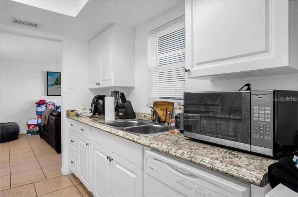 2604 Lemon Tree Lane, Unit C Orlando, FL 32839 - Photo 18 of 24 a kitchen with granite countertop a sink a stove and cabinets