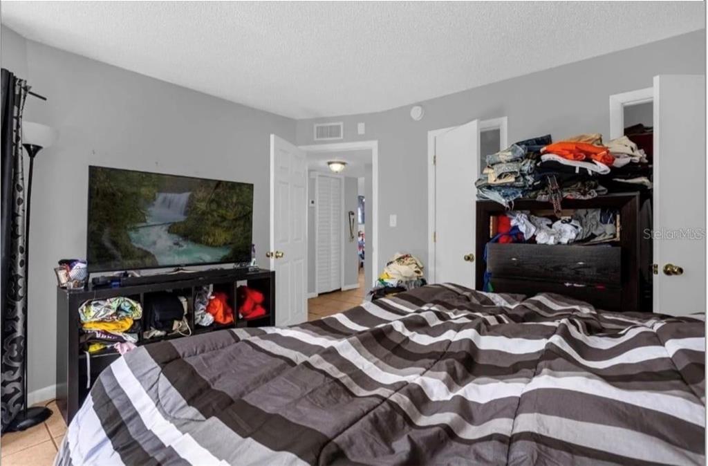 2604 Lemon Tree Lane, Unit C Orlando, FL 32839 - Photo 21 of 24 a bedroom with a bed and a flat screen tv