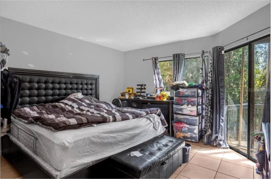 2604 Lemon Tree Lane, Unit C Orlando, FL 32839 - Photo 22 of 24 a bed sitting in a bedroom next to a window