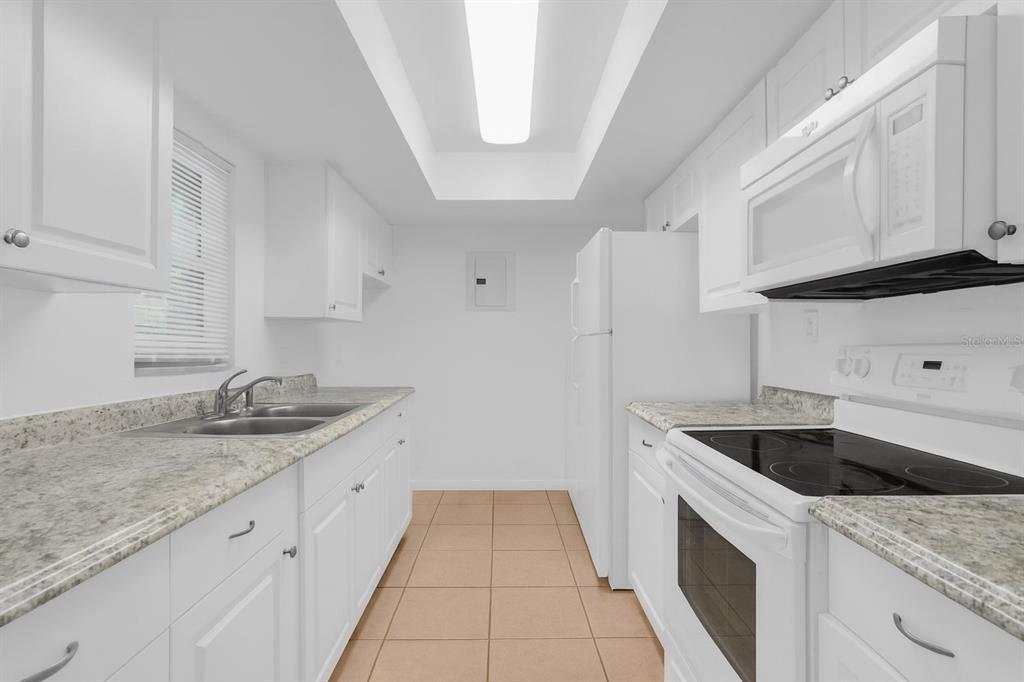 2604 Lemon Tree Lane, Unit C Orlando, FL 32839 - Photo 7 of 24 a kitchen with granite countertop white cabinets and white appliances