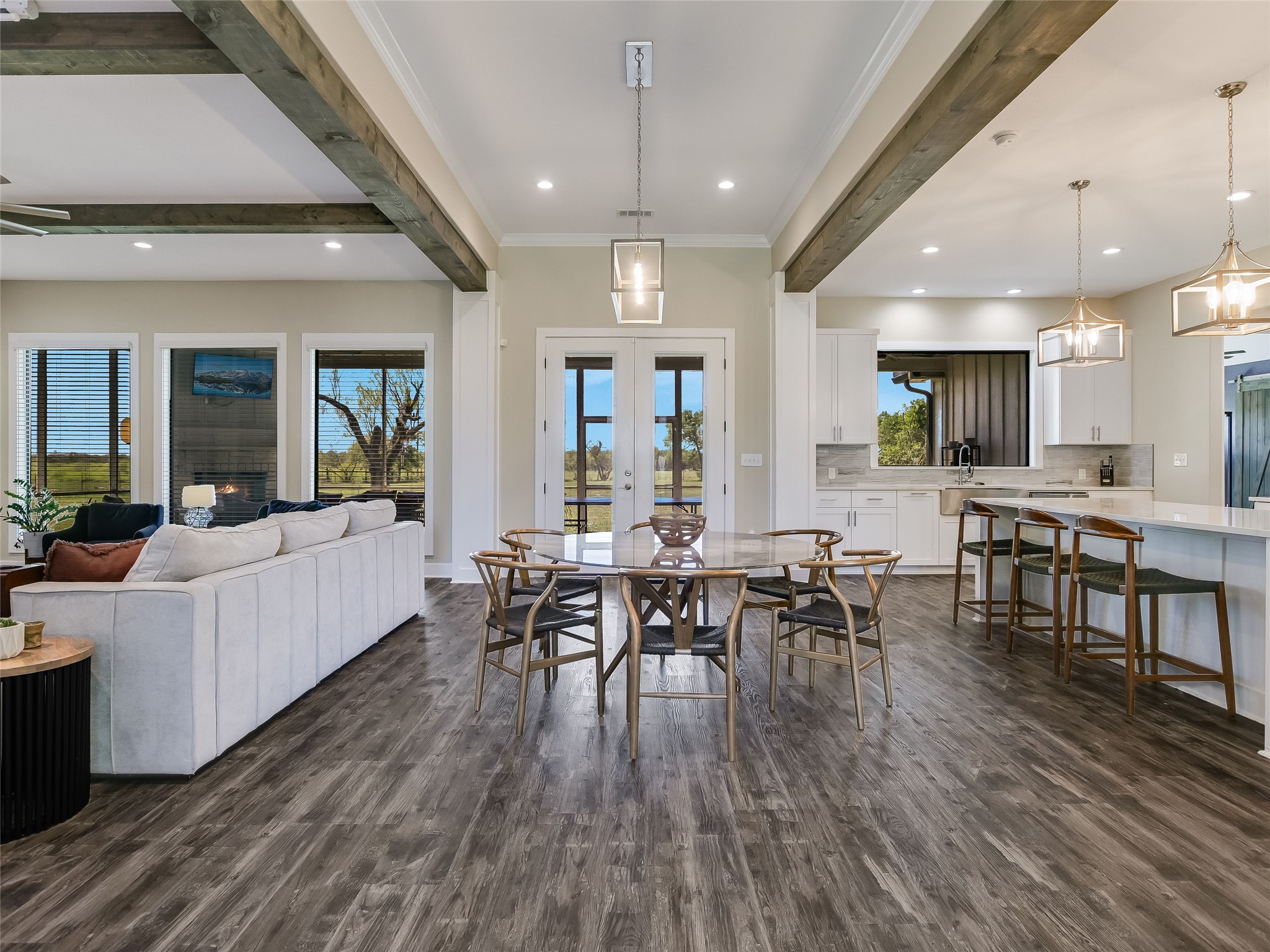 The heart of the home showcases exposed ceiling beams, seamless indoor-outdoor flow, and a layout designed for entertaining and connection.