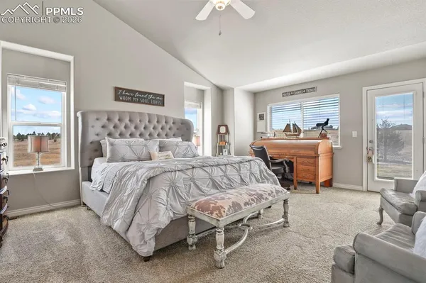 a bedroom with a bed and large windows