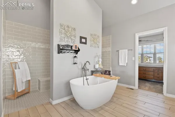 a white bath tub sitting in a bathroom next to a window
