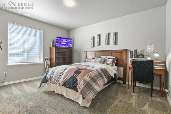 a spacious bedroom with a bed and a table in it with window