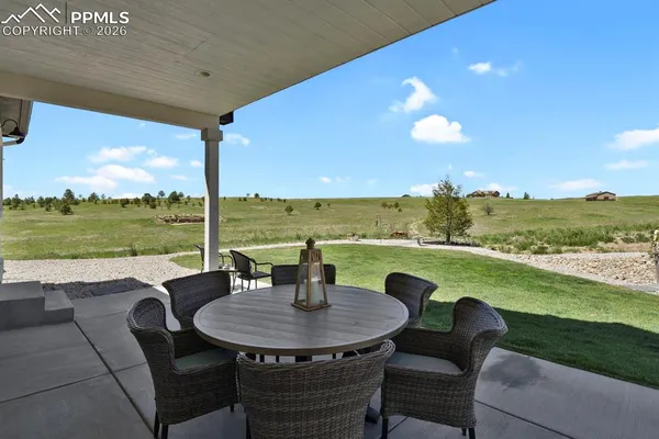 a view of a patio with lawn chairs and a table
