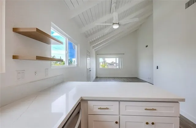 a kitchen with white cabinets stainless steel appliances and window