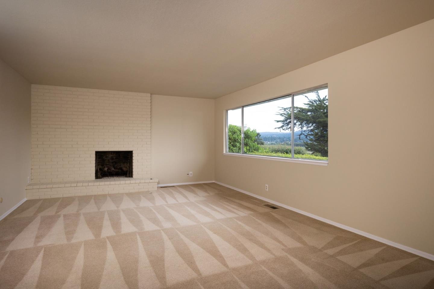 2960 Ribera Road Carmel, CA 93923 - Photo 11 of 19 a view of an empty room with a window and a fireplace