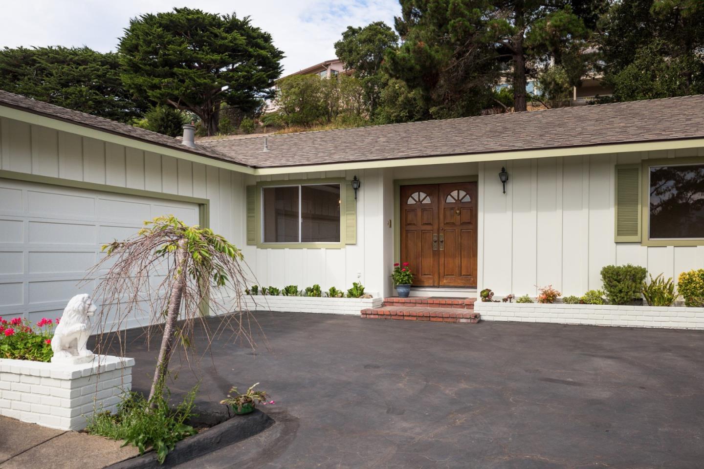2960 Ribera Road Carmel, CA 93923 - Photo 18 of 19 a front view of a house with a yard and potted plants