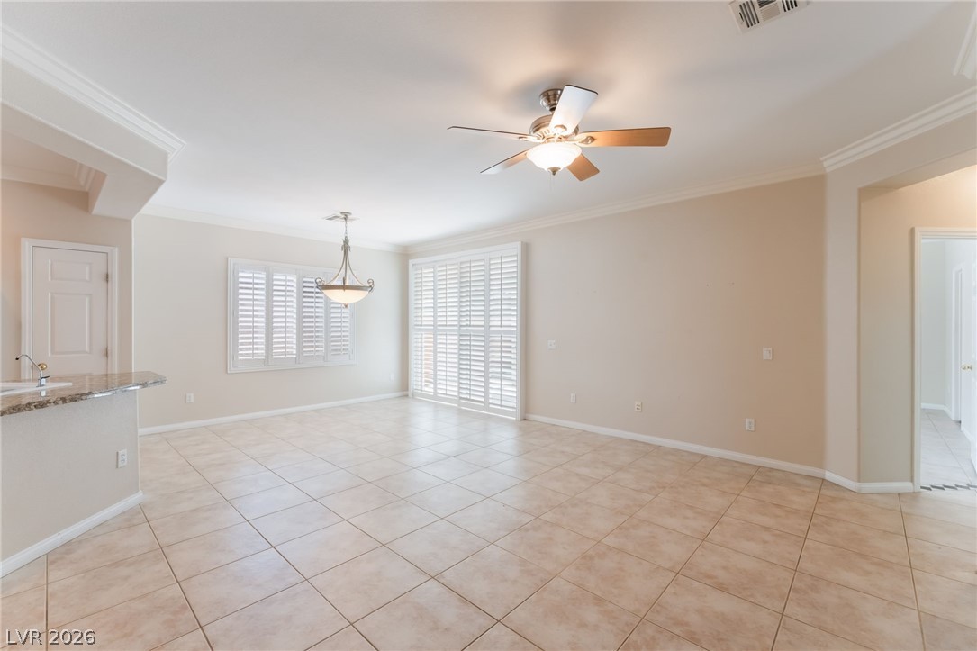 10481 Riverside Park Avenue Las Vegas, NV 89135 - Photo 8 of 51 Empty room featuring a ceiling fan, ornamental molding, and light tile patterned floors