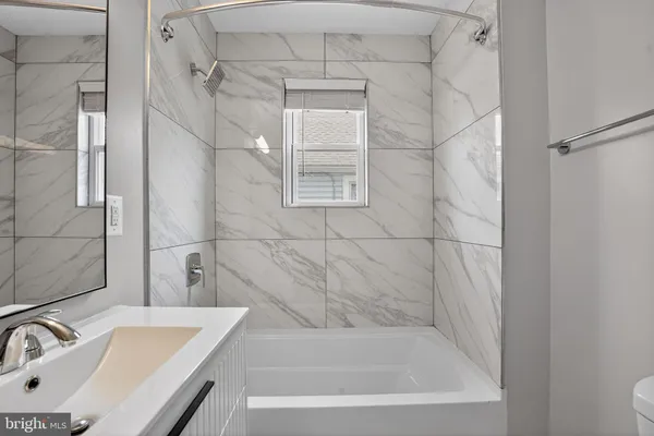 a bathroom with a shower a mirror and a sink