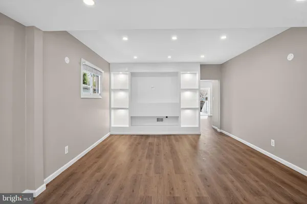 a view of empty room with wooden floor and windows