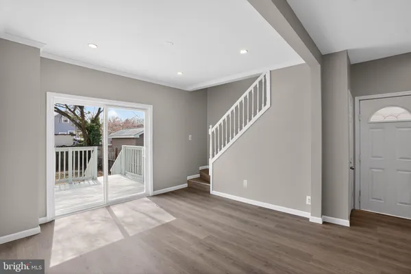 a view of a big room with wooden floor and a hallway