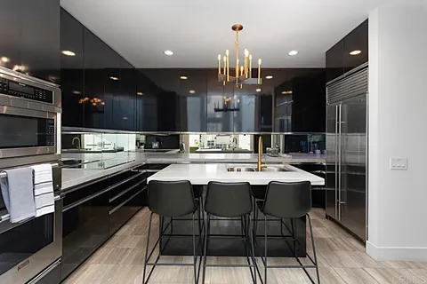 a kitchen with a sink a counter space appliances and cabinets