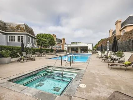 a swimming pool with outdoor seating and barbeque oven