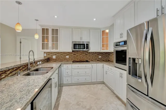 a kitchen with granite countertop a sink stove and refrigerator