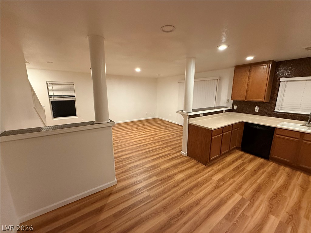 Warm wood flooring flows seamlessly through an open concept kitchen and living area.