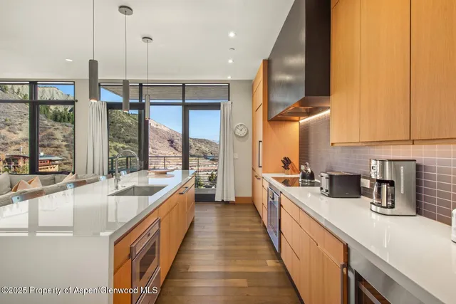 a kitchen with stainless steel appliances granite countertop a table chairs sink and cabinets
