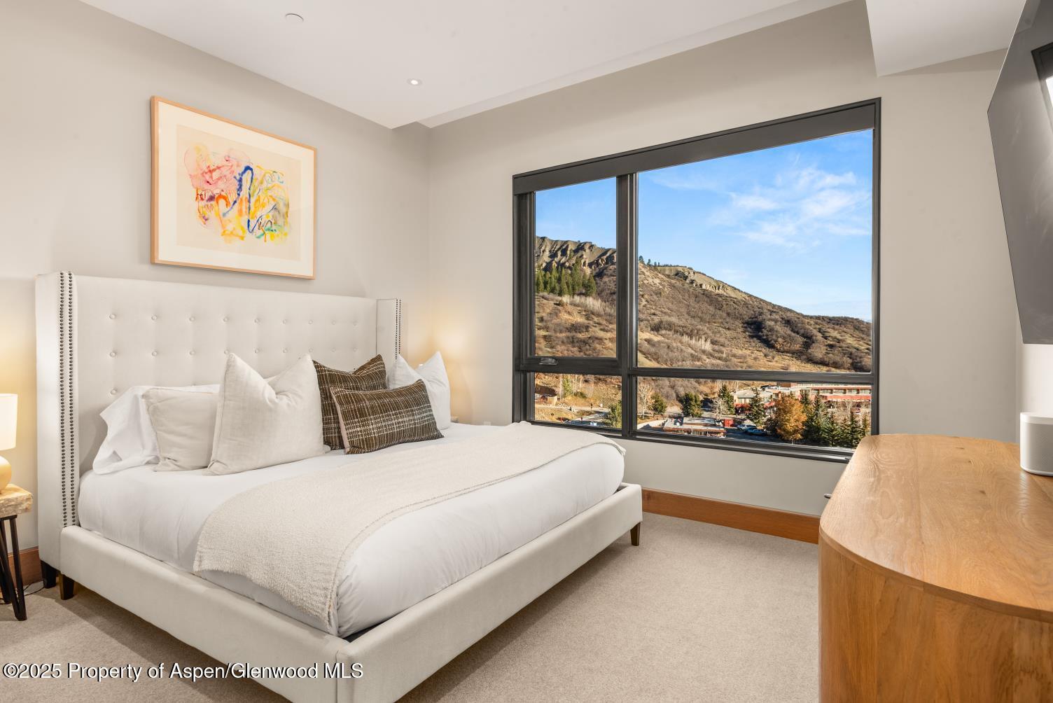 77 Wood Road, Unit 603 Snowmass Village, CO 81615 - Photo 18 of 45 a bedroom with a large bed and a large window