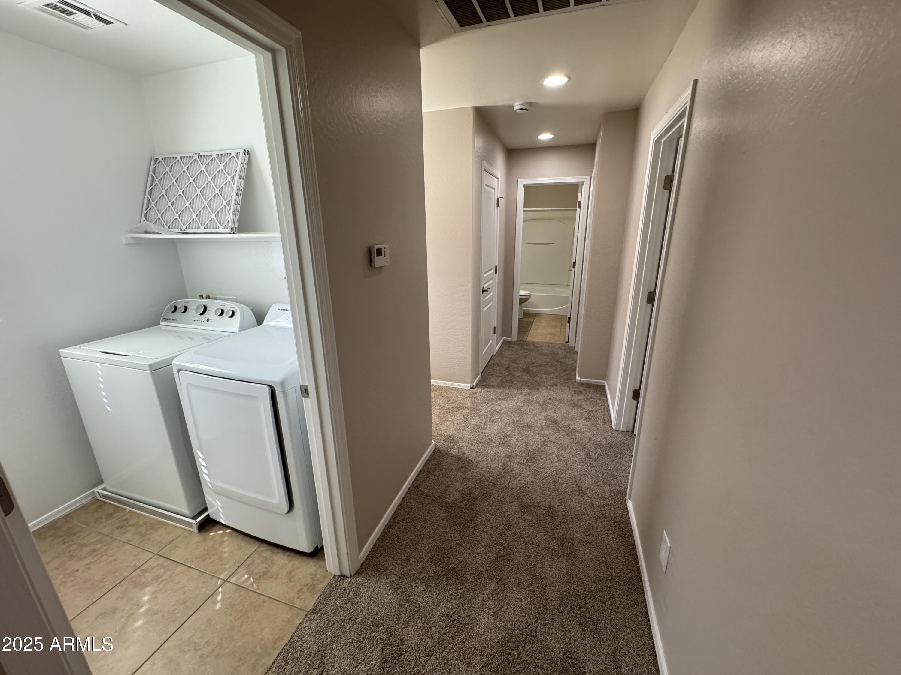 3822 East Santa Fe Lane Gilbert, AZ 85297 - Photo 9 of 24 a view of a hallway with cabinets and a refrigerator