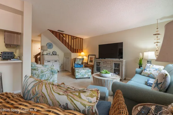 a living room with furniture a flat screen tv and a lamp