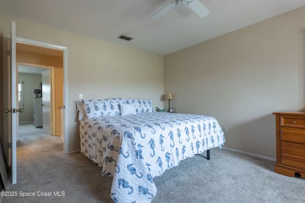 a bedroom with a bed and a lamp on the dresser