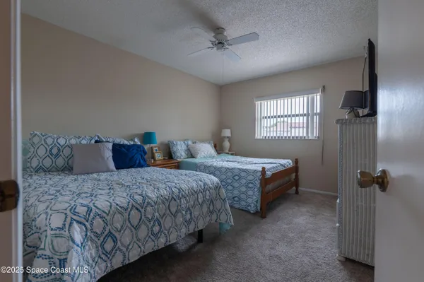 a bedroom with two beds and windows