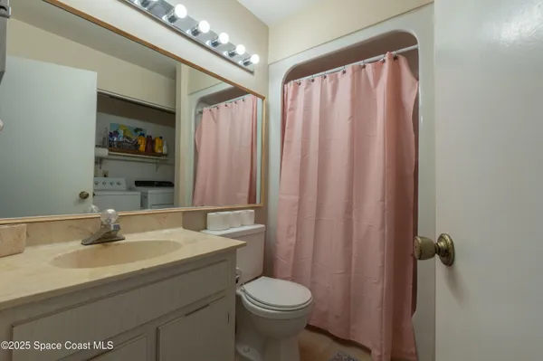 a bathroom with a sink a toilet and shower curtain