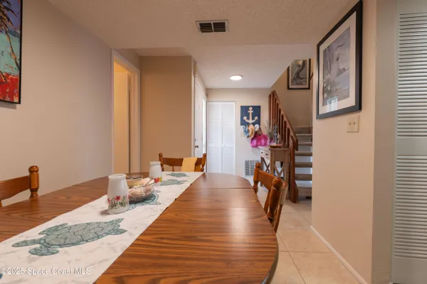 a hallway with a couch and a dining table with wooden floor