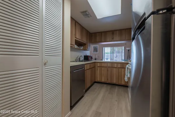 a kitchen with a refrigerator and white cabinets