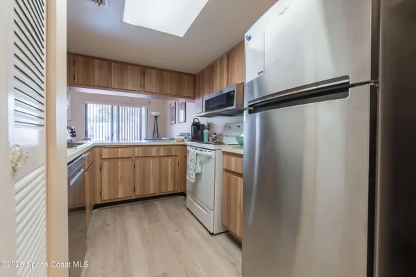 a kitchen with white cabinets and white appliances