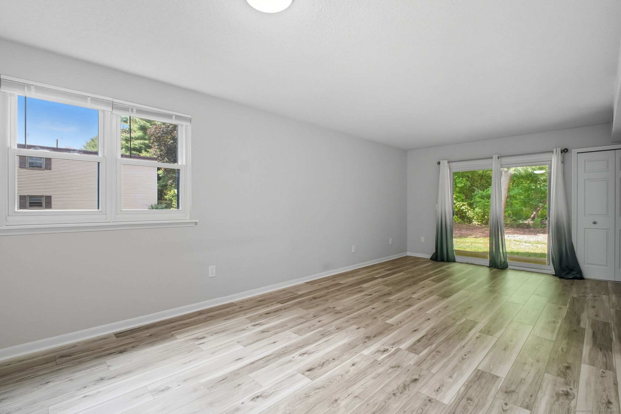 402 Twin Circle Drive, Unit 402 South Windsor, CT 06074 - Photo 4 of 18 a view of an empty room with wooden floor and a window