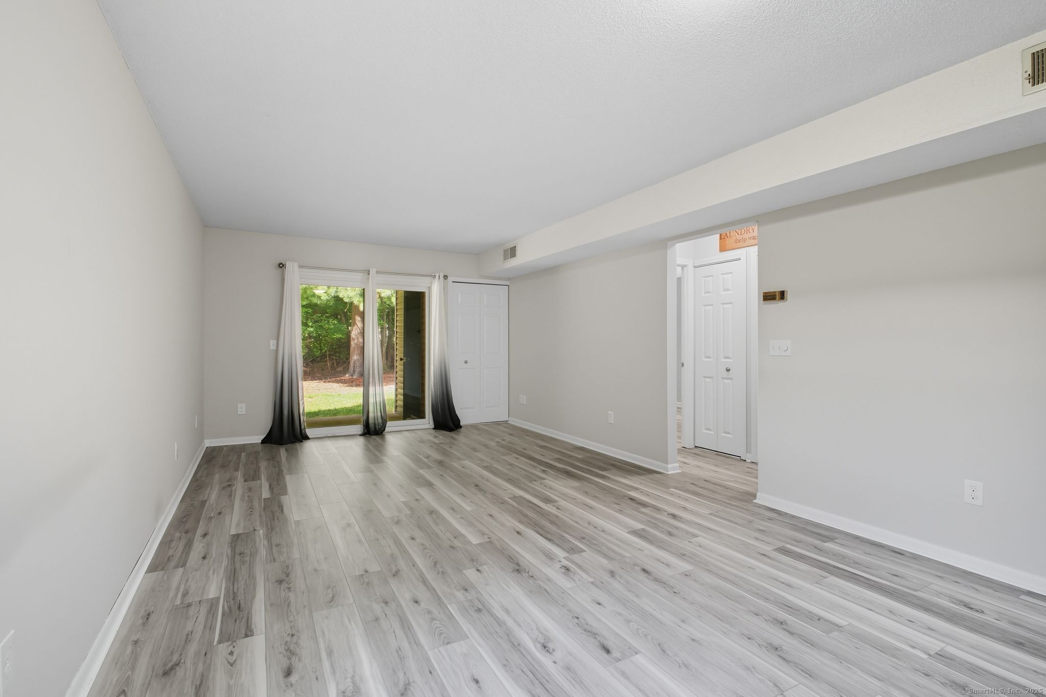 402 Twin Circle Drive, Unit 402 South Windsor, CT 06074 - Photo 5 of 18 a view of an empty room with wooden floor and a window